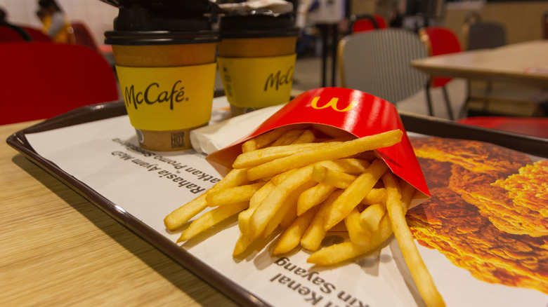 Two McCafe coffees and fries on a tray