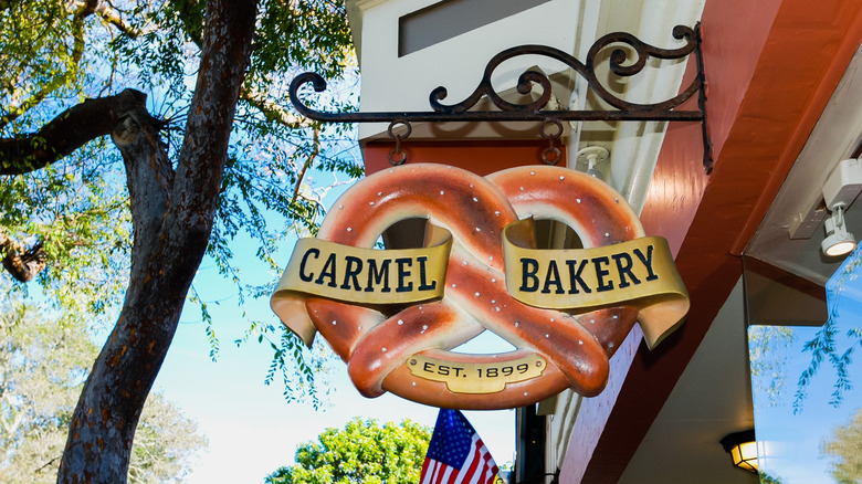 a sign made to look like a pretzel for the Carmel Bakery hanging outside the shop