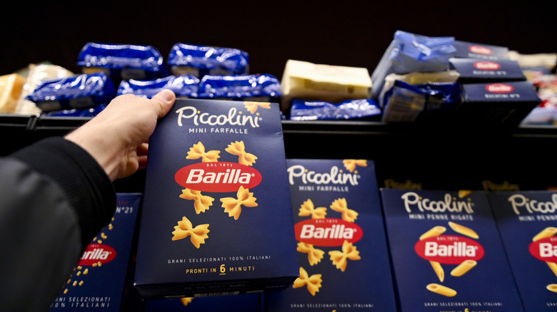 A person reaches for a packet of Barilla pasta