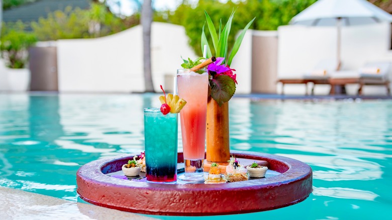 Cocktails on a floating tray in a pool
