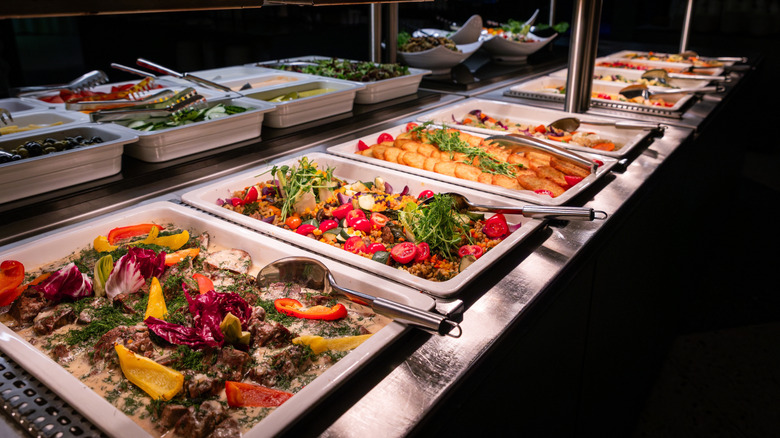 Buffet table with various hot and cold dishes