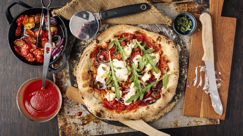 homemade pizza with ingredients being made