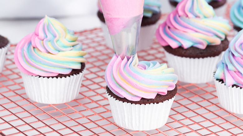 piping rainbow buttercream frosting, cupcakes