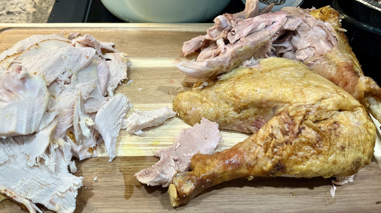 a cutting board with carved poultry on it, some of it with a pinkish tinge