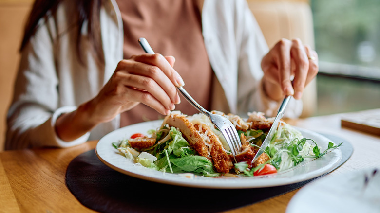 person eating salad at table