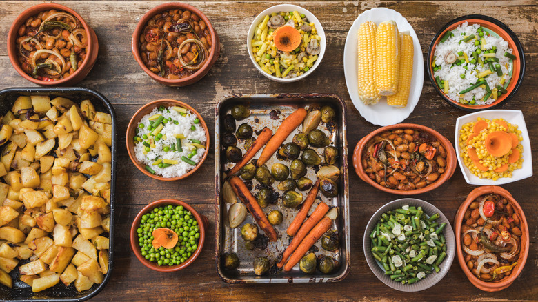 lots of different side dishes arrayed on a wooden table