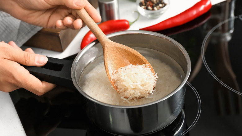 Person boiling rice on stove