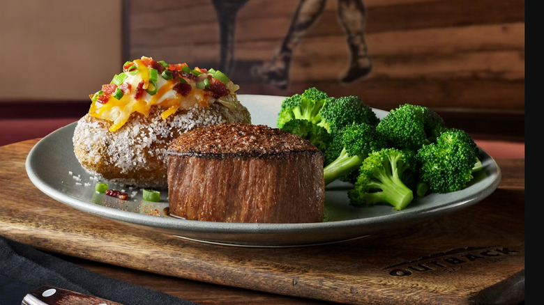 filet mignon on a plate with a loaded baked potato and broccoli