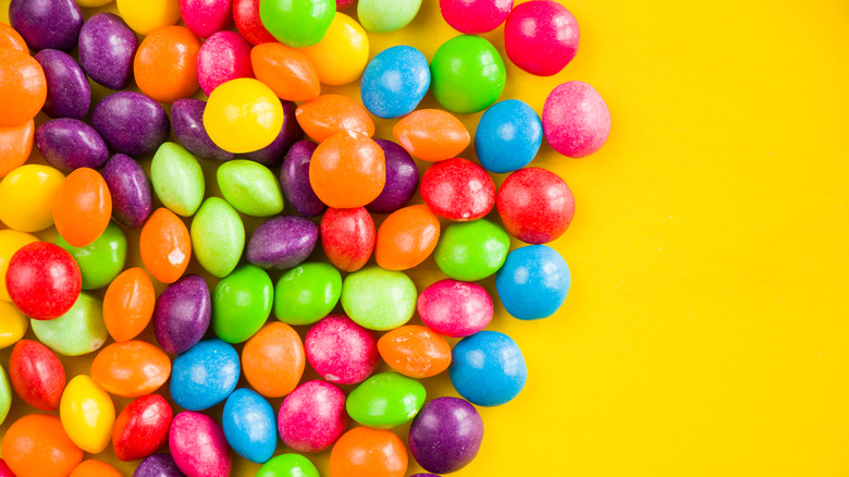 Skittles candy on a yellow background