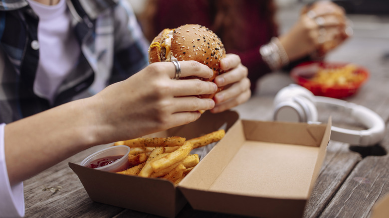 person eating a fast food burger and fries