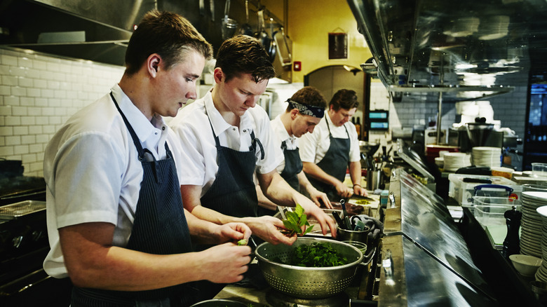Large kitchen with line cooks and staff working