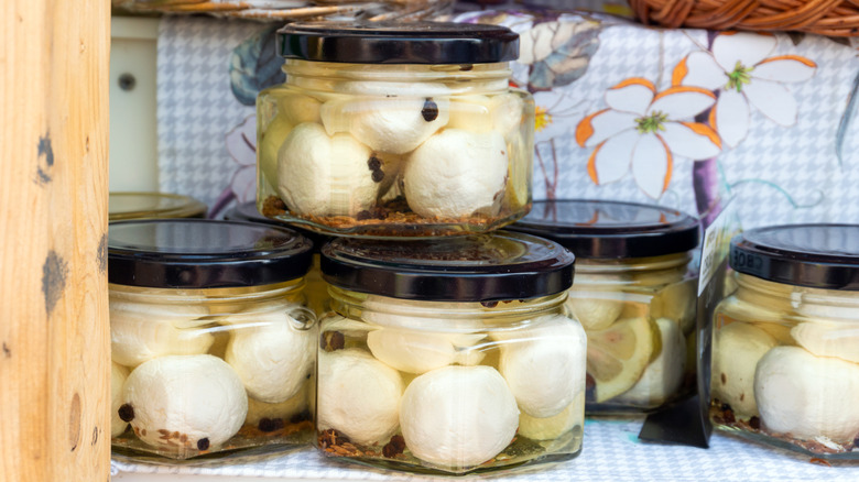 Glass jars filled with mozzarella balls soaking in a brine