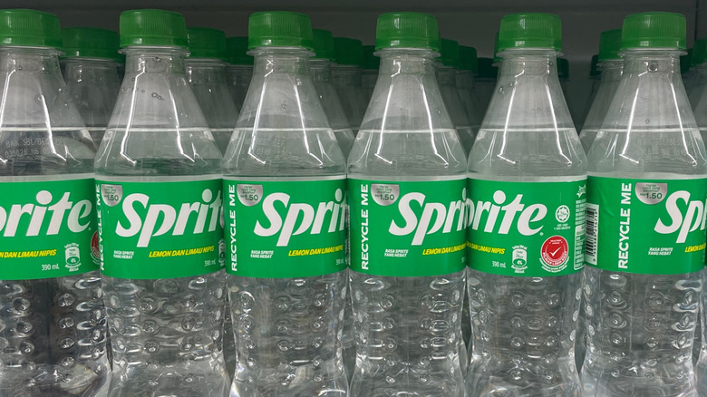 Clear bottles of Sprite with green Lids lined up on a store shelf