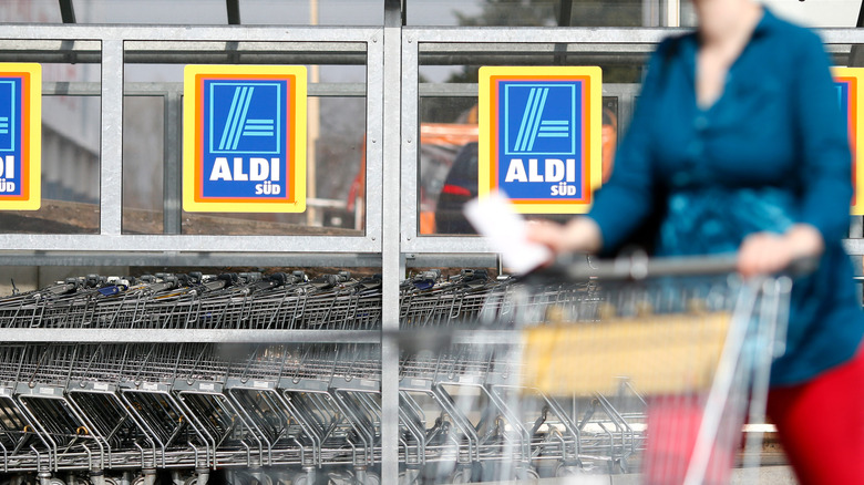 Aldi shopper pushing cart outside of store