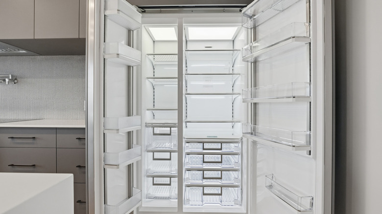 An empty refrigerator with doors wide open