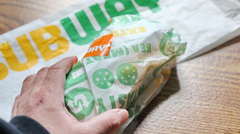 Subway sandwich maker holding sub