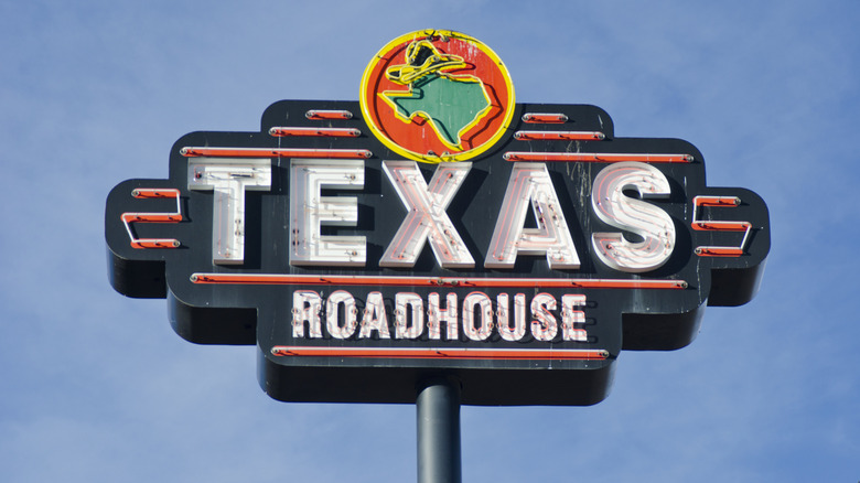 Texas Roadhouse sign against a bright blue sky