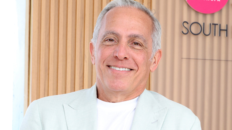 Geoffrey Zakarian smiles in light blue blazer and white shirt