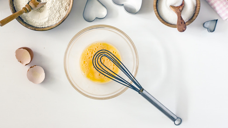 A flat whisk beating eggs