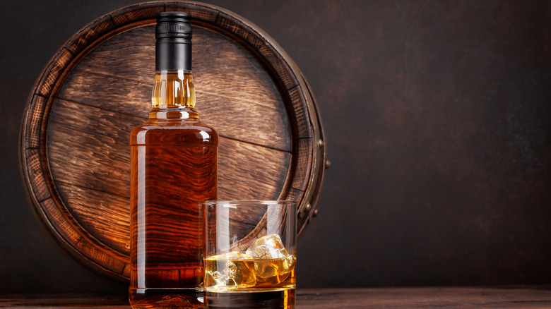 bourbon bottle, barrel, and glass