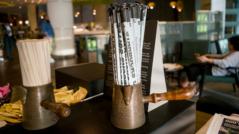 The condiment bar at Starbucks with straws and sugar packets