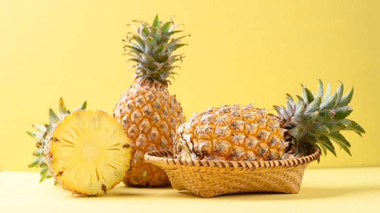 fresh pineapples on yellow background
