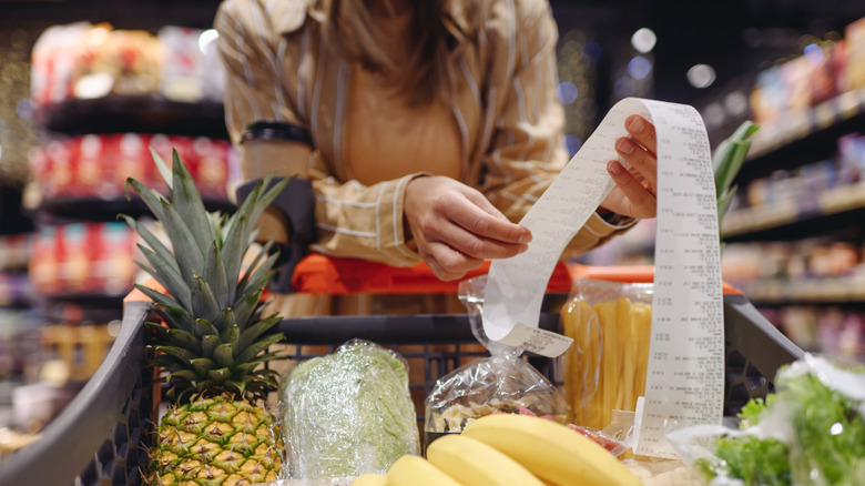 close up of woman look over grocery receipt