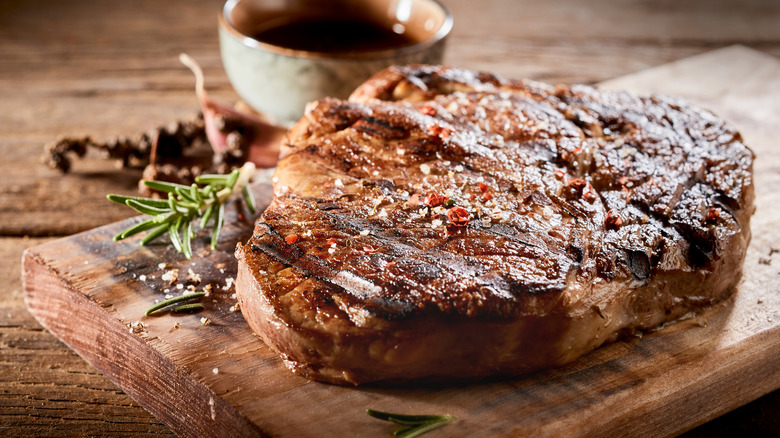 steak on a wooden board with rosemary