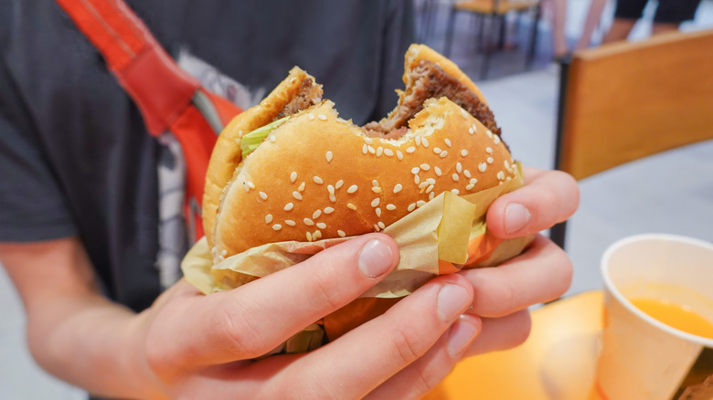Teen holding a fast food burger