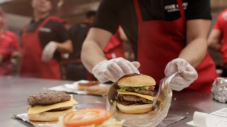 Five Guys employee assembling a burger
