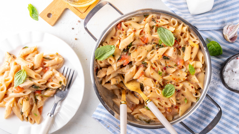a pot of pasta with a plate of pasta on the side