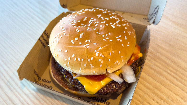 McDonald's Double Quarter Pounder with Cheese inside cardboard box on wooden surface