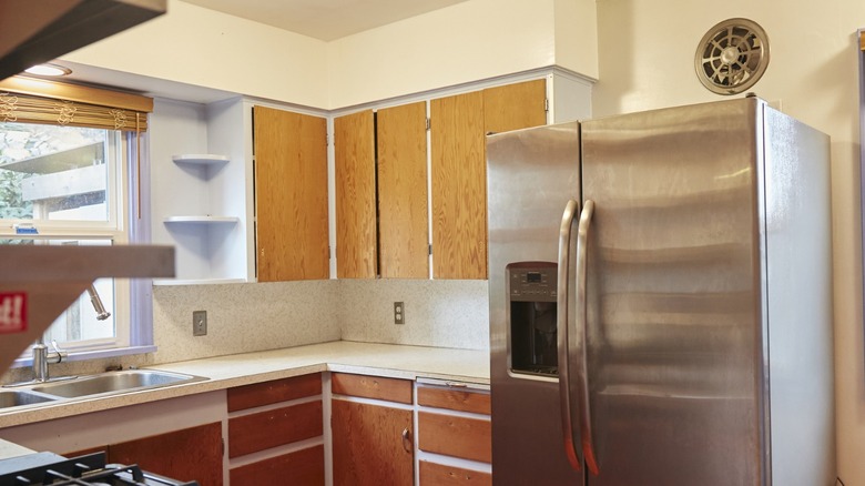 A kitchen with white soffits above wood grain cabinets