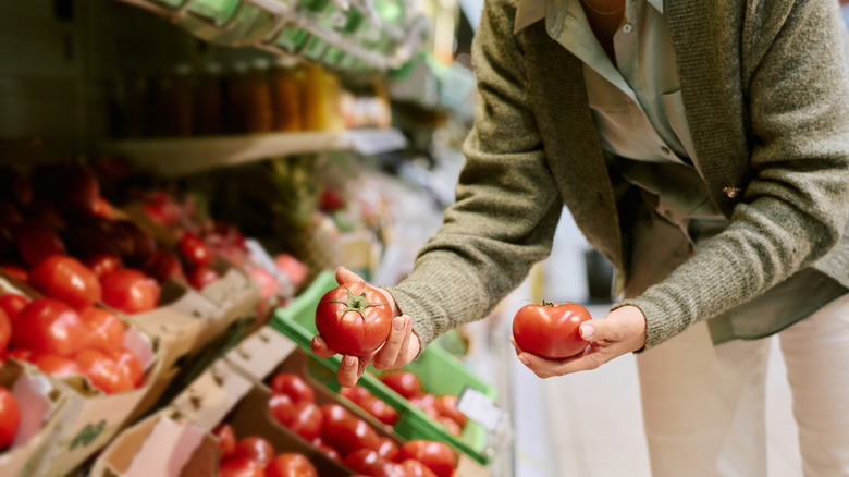 shopper looking at tomatoes at grocery store