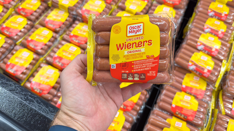 hand holds up uncured Oscar Mayer wieners
