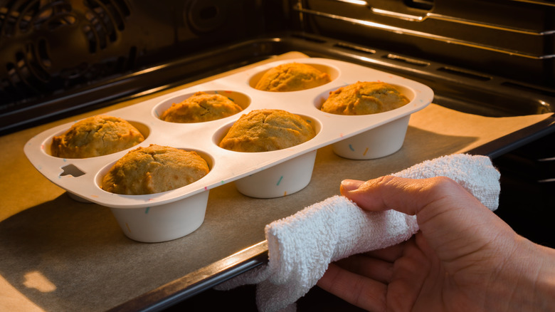 Cupcakes are baking on top of a sheet pan in the oven.