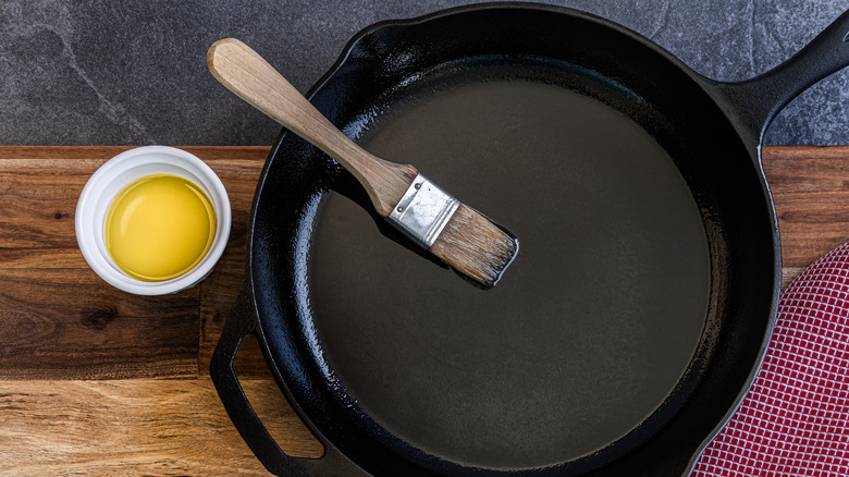 overhead shot of cast iron pan with olive oil and brush