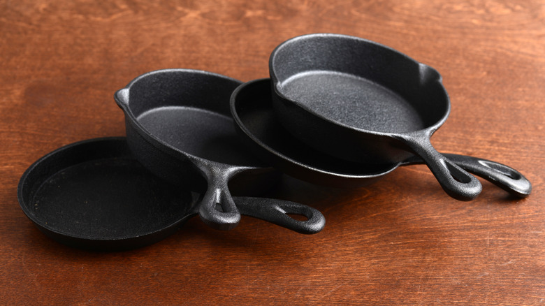 stack of small cast iron pans on table