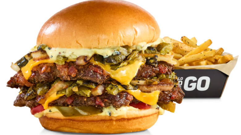 The bacon smashed hatch chile burger by wild burger by buffalo wild wings with an order of fries in the background