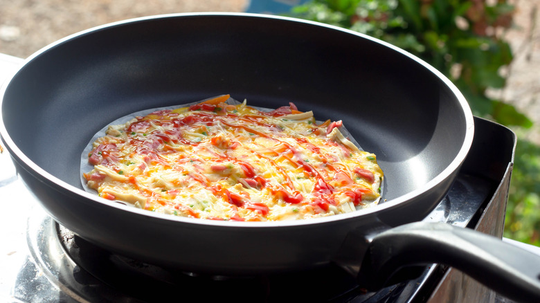 Cooking rice paper omelet in frying pan