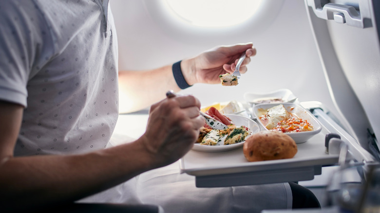 Person eating airplane food in flight