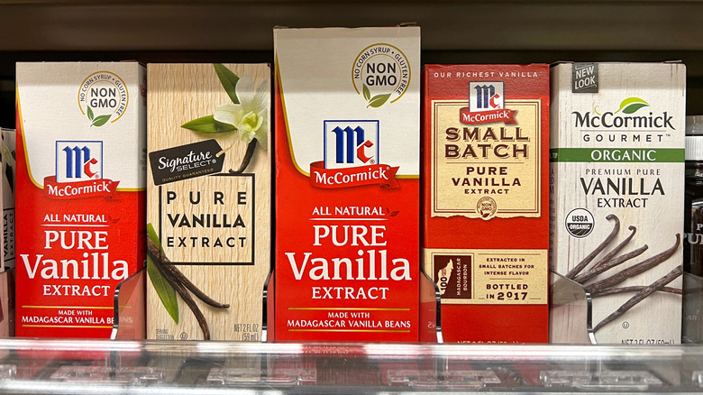 Shelf containing boxes of various brands of vanilla extract