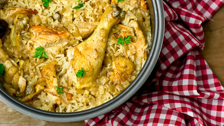 Chicken and rice in slow cooker next to gingham napkins