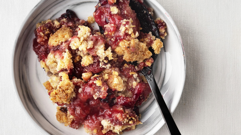 Plate of berry crumble with a spoon in it