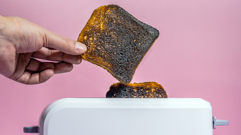 Grabbing burnt toast from toaster oven