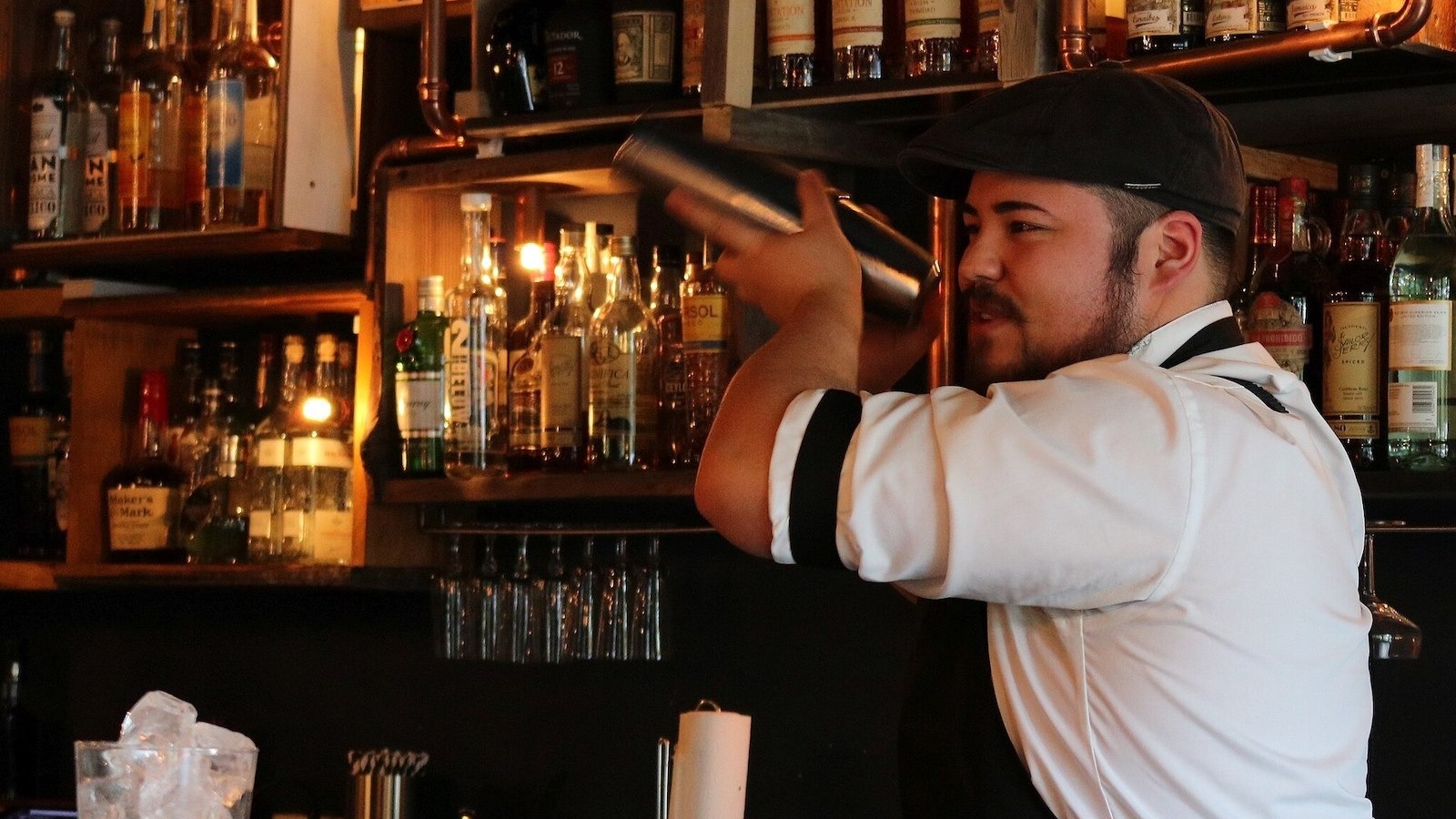 Why You See Bartenders Shaking Drinks Over Their Shoulders