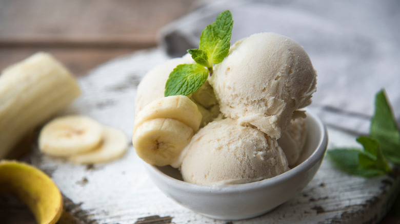 vanilla ice cream in bowl with banana and mint leaf