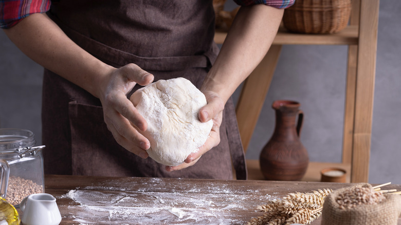 hands holding bread dough 