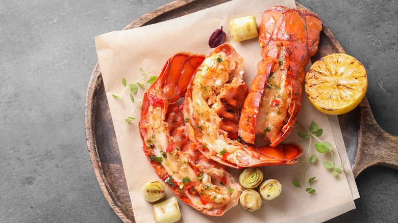 Three pieces of lobster tail on wax paper with lemon half