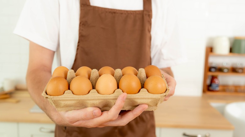 person holding tray of eggs